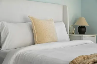 a white bed with a pillow on top of it at Silver Springs Family Retreat in Calgary