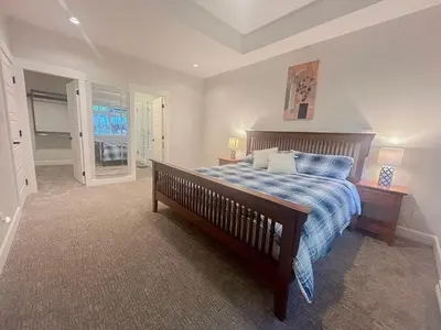 a bedroom with a bed with a blue comforter at Charming scape by Bear Mountain in Victoria