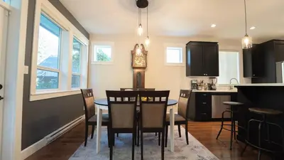 a kitchen and dining room with a table and chairs at Charming scape by Bear Mountain in Victoria