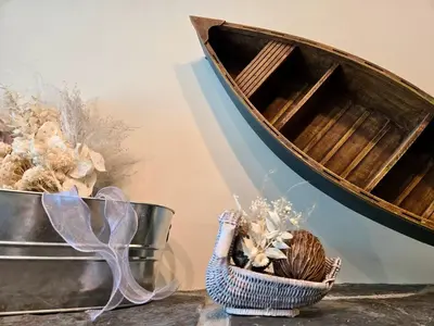 a wooden boat on a table with a basket of flowers at Pika's Place Bed and Breakfast in Canmore