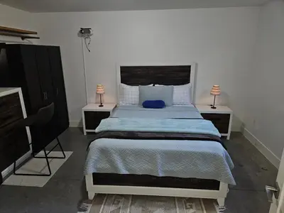 a bedroom with a bed with two night stands and two lamps at The Ridge in North Vancouver