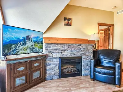 a living room with a fireplace and a flat screen tv at Heron Point by StayIn in Invermere