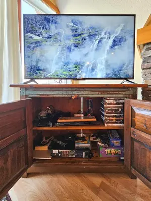a tv on top of a wooden entertainment center at Heron Point by StayIn in Invermere