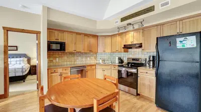 a kitchen with a table and a black refrigerator at Heron Point by StayIn in Invermere