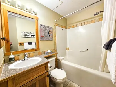 a bathroom with a sink and a toilet and a tub at Heron Point by StayIn in Invermere