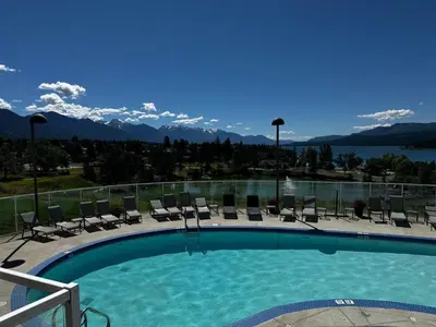 a swimming pool with chairs and a view of the mountains at Heron Point by StayIn in Invermere