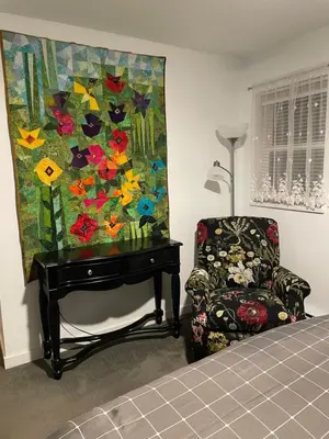a bedroom with a chair and a painting on the wall at Oyster River Guest Room in Campbell River