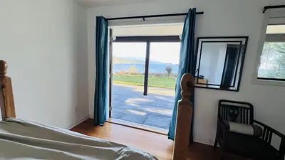 a bedroom with a sliding glass door with a view at Oceanfront Garden Suite - Stunning Views & Wildlife in Halfmoon Bay