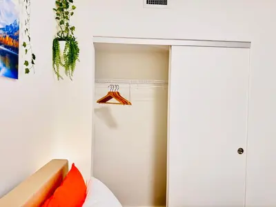 a bedroom with a closet and a bed with orange pillows at Bow River Cabin - Downtown - River Front - Free Street Parking in Calgary