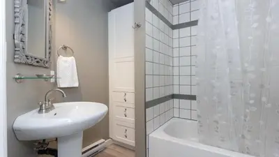 a white bathroom with a sink and a shower at Cole's Bay Vacation Retreat Cole's Bay Suite in YYJ