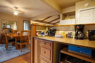 a kitchen with a counter and a dining room at Cole's Bay Vacation Retreat Petie's Cottage in YYJ