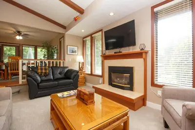 a living room with a couch and a fireplace at Cole's Bay Vacation Retreat Petie's Cottage in YYJ