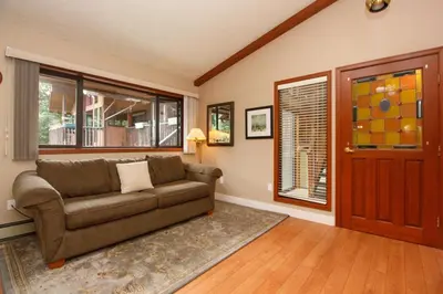 a living room with a couch and a window at Cole's Bay Vacation Retreat Petie's Cottage in YYJ