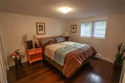 a bedroom with a large bed and a window at Grand Boulevard Retreat- quiet suite in North Vanc in North Vancouver