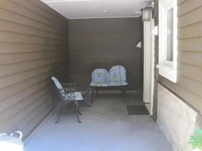 two chairs sitting on a porch next to a window at Grand Boulevard Retreat- quiet suite in North Vanc in North Vancouver