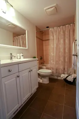 a bathroom with a sink and a toilet and a shower at Grand Boulevard Retreat- quiet suite in North Vanc in North Vancouver