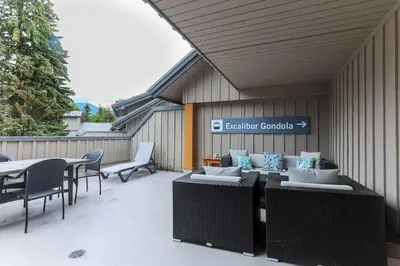 a patio with tables and chairs and a table and chairs at Whistler Village North Retreat - Private Hot tub in Whistler