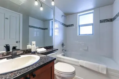 a bathroom with a sink and a toilet and a tub at Whistler Village North Retreat - Private Hot tub in Whistler