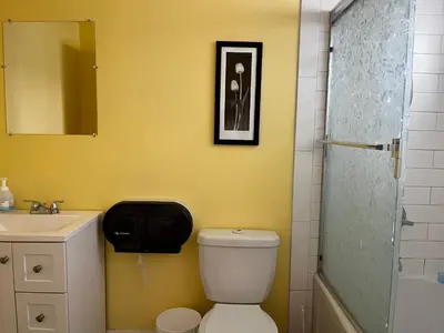 a yellow bathroom with a toilet and a sink at Biddington private room close airport! in Calgary