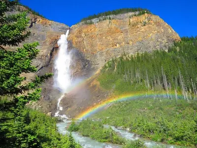 a rainbow at the bottom of a waterfall at Newly Built 2BR Mountain Escape in DT Canmore! in Canmore