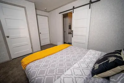a bedroom with two white doors and a bed at 3 Bed Townhouse, Mountain Views, Large Deck, Air Con, Garage in Invermere