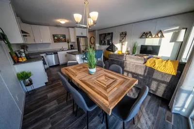a kitchen and living room with a table and a couch at 3 Bed Townhouse, Mountain Views, Large Deck, Air Con, Garage in Invermere