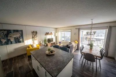 a living room with a kitchen and a living room with a table at 3 Bed Townhouse, Mountain Views, Large Deck, Air Con, Garage in Invermere