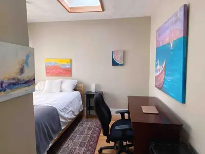 a bedroom with a desk and a bed and a desk and chair at Craftsman Home in popular East Village in Vancouver