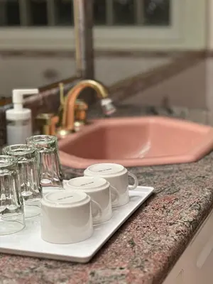 a counter with cups and glasses and a sink at Spacious Bedroom with Two Queen Sized Bed in Richmond