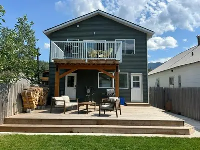 a house with a deck with a dog on the balcony at 2 BDRM Homes on 2nd Avenue in Fernie