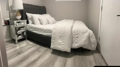 a bedroom with a bed with a white comforter at Private one Bedroom Suite for Rent in Calgary