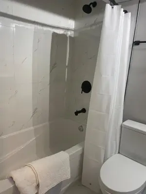 a bathroom with a tub and a toilet and a shower at Private one Bedroom Suite for Rent in Calgary