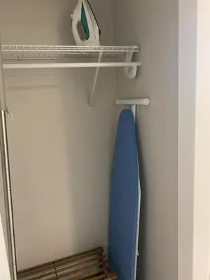 a closet with a blue surfboard on a shelf at Private one Bedroom Suite for Rent in Calgary