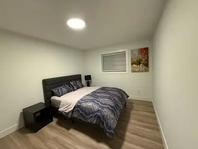 a bedroom with a bed and a picture on the wall at Calm & Cozy Private Suite in Surrey
