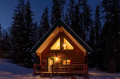 a small log cabin in the snow at night at Moberly Lodge in Golden