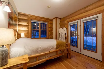 a log cabin bedroom with a bed and windows at Moberly Lodge in Golden