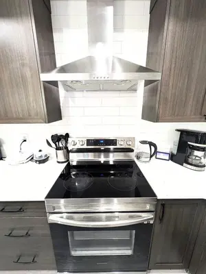 a kitchen with a stove top oven in a kitchen at Edith Gate Luxe Bedroom 2 Homestay in Calgary