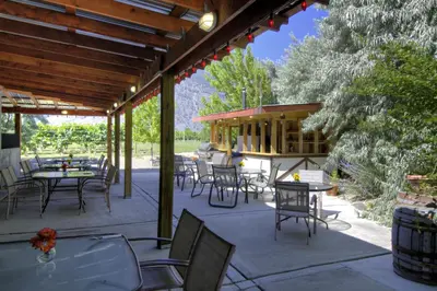 a patio with tables and chairs and a pavilion at Crowsnest Vineyards Guesthouse in Keremeos
