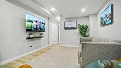 a living room with a couch and paintings on the wall at Serene Stays in Calgary