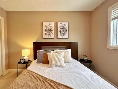 a bedroom with a bed with two pictures on the wall at Entire Beautiful and Cozy Home in Edmonton