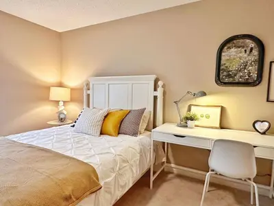 a bedroom with a white bed and a desk at Entire Beautiful and Cozy Home in Edmonton