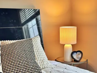 a bedroom with a bed with a lamp and a window at Entire Beautiful and Cozy Home in Edmonton
