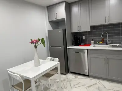 a kitchen with a white table and a vase with flowers at Modern & Stylish Private Suite in Pine Creek in Calgary
