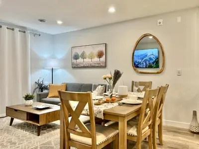 a dining room with a table and a couch at Mountain View New Luxury Condo at Banff Entrance in Canmore