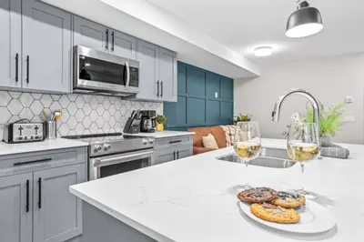 a kitchen with two glasses of wine and donuts on a counter at Charming 2BR Haven in Canmore Near DT and Banff in Canmore