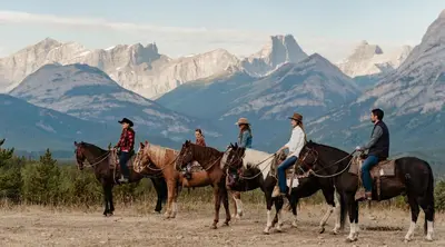 a group of people riding horses in the mountains at Skyridge Glamping in Kananaskis Village