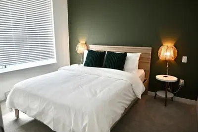 a bedroom with a large white bed and two lamps at Stylish 2-Bedroom Condo - Premium Comfort, Central Location in Surrey