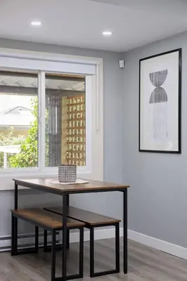 a table and bench in a room with a window at Spacious 4BR Retreat near YVR and DT in Vancouver