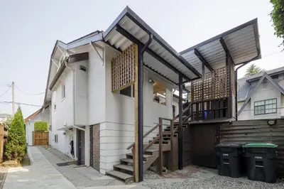 a house with a wooden staircase and a balcony at Spacious 4BR Retreat near YVR and DT in Vancouver