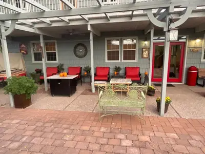 a patio with red chairs and a table in front of a house at Blackbird Glen Bed and Breakfast, Glenmore, Kelowna, BC in Kelowna